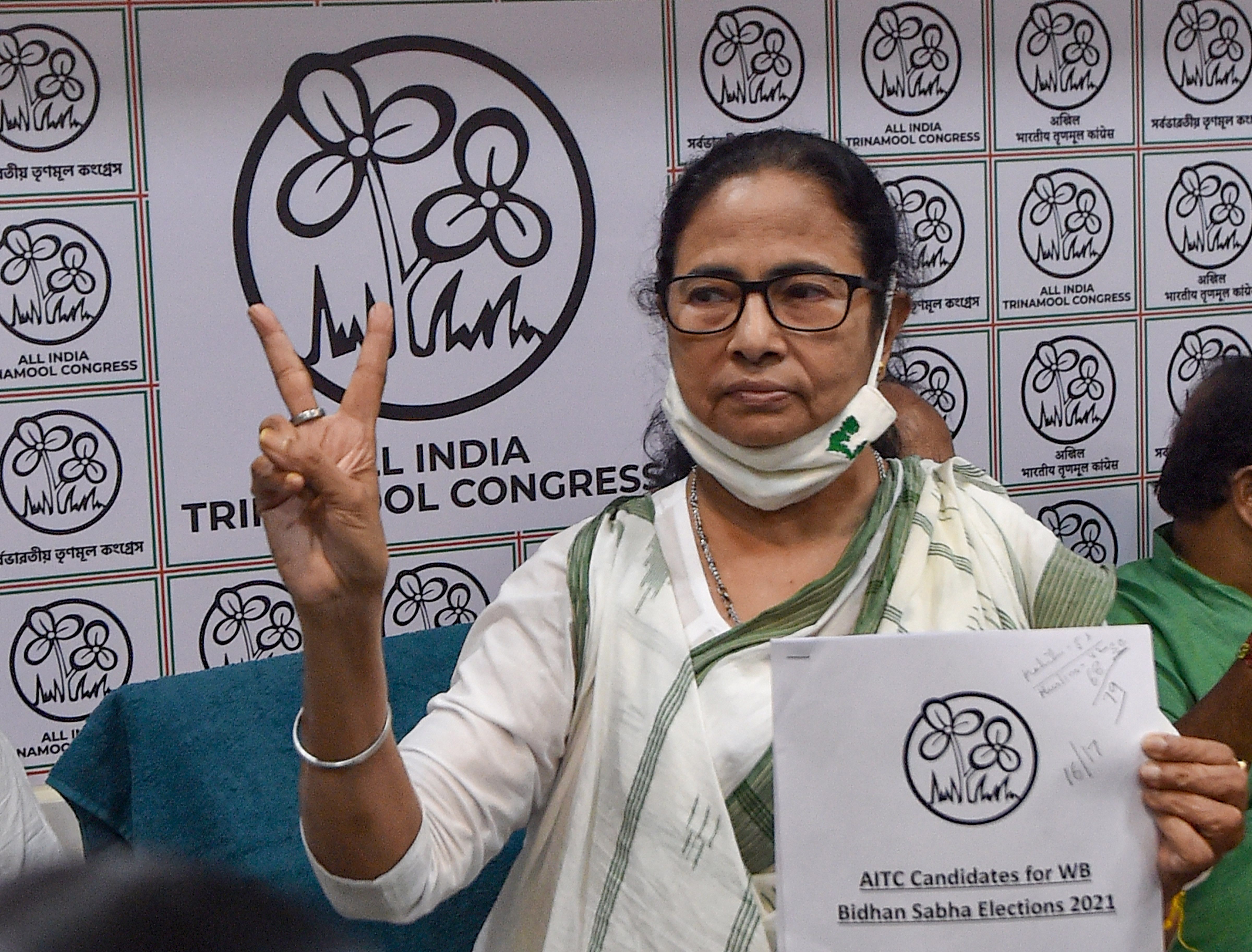 Mamata Banerjee flashes a victory sign with the list of electoral candidates at Trinamool Congress party office. Credit: PTI Photo