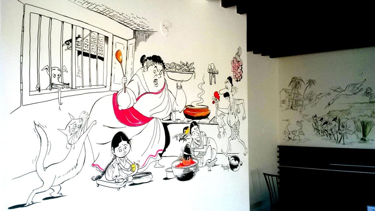 A wall cartoon by cartoonist Prakash Shetty at ‘Mangalore Pearl’, capturing the buzz of activities in a kitchen of an undivided family, among other cultural facets of Tulunadu, painted on the walls in the form of cartoons. Credit: Picasa.