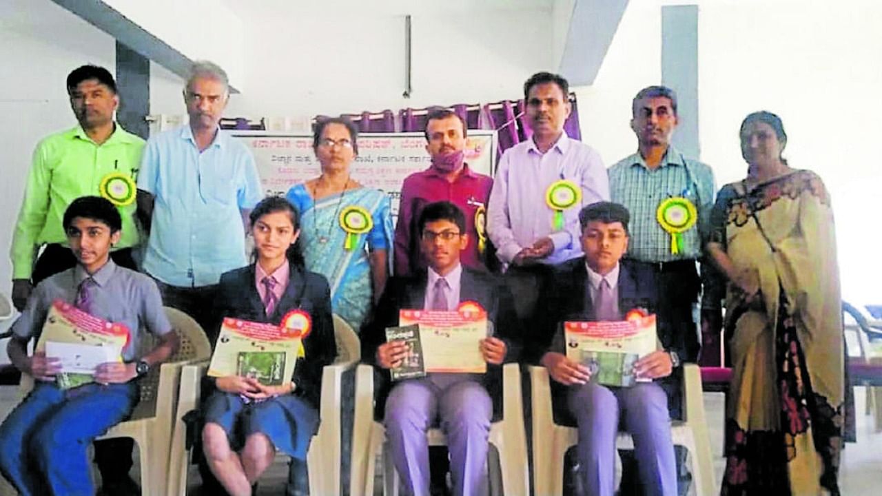 The winners of the district-level quiz competition with the dignitaries in Madikeri. Credit: Special arrangement.