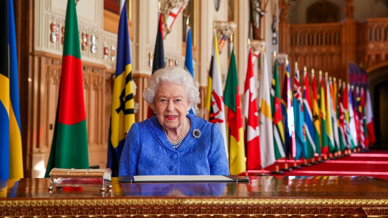 In this photo made available Sunday March 7, 2021, Britain's Queen Elizabeth II poses for a photo while signing her annual Commonwealth Day Message inside St George's Hall at Windsor Castle, England, Friday March 5, 2021. Credit: AP/PTI Photo