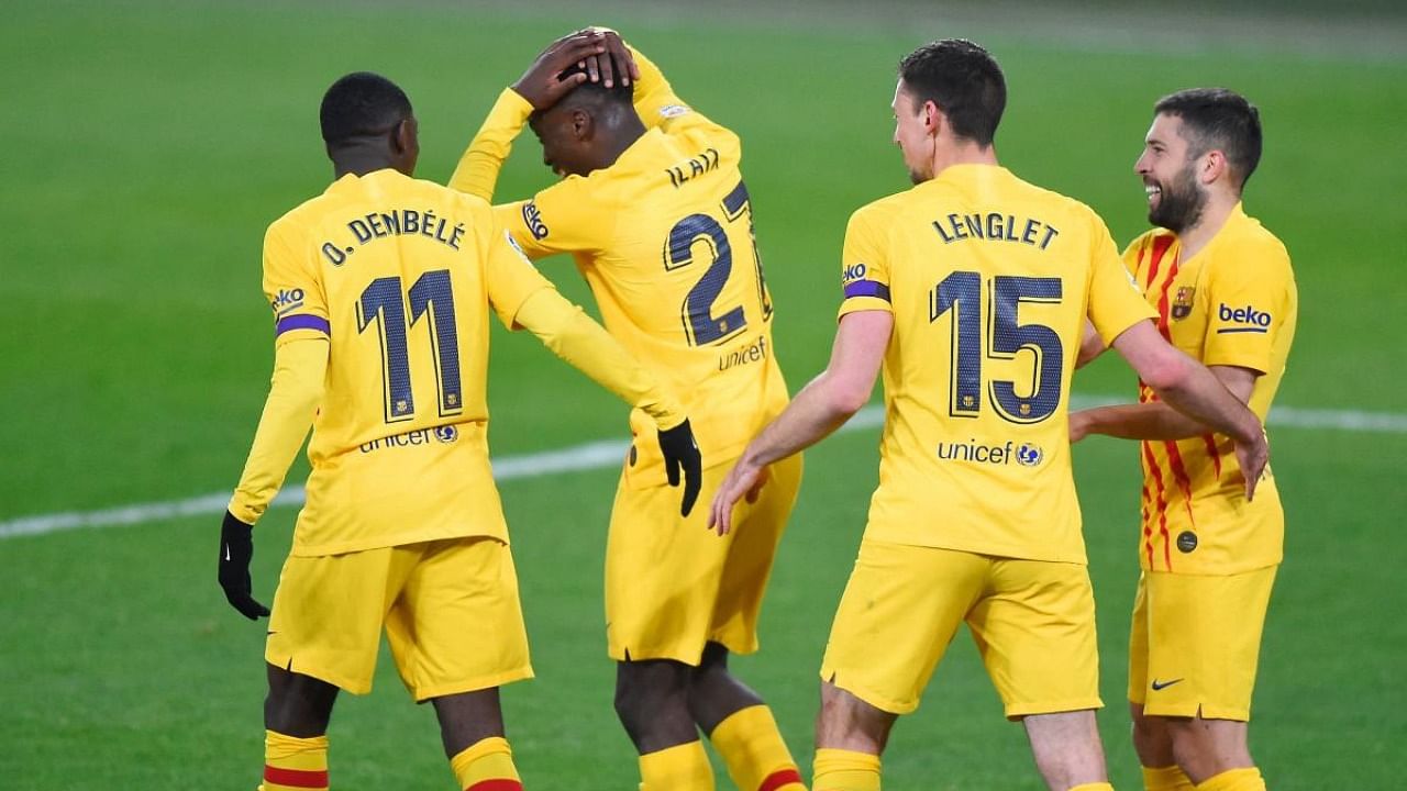 Barcelona's Spanish midfielder Ilaix Moriba (2L) celebrates with Barcelona's French forward Ousmane Dembele, Barcelona's French defender Clement Lenglet and Barcelona's Spanish defender Jordi Alba after scoring during the Spanish League football match between CA Osasuna and FC Barcelona at El Sadar stadium in Pamplona on March 6, 2021. Credit: AFP.