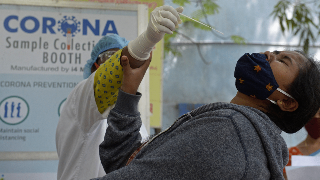 A health worker collects a swab sample from a woman to test for the Covid-19. Credit: AFP Photo