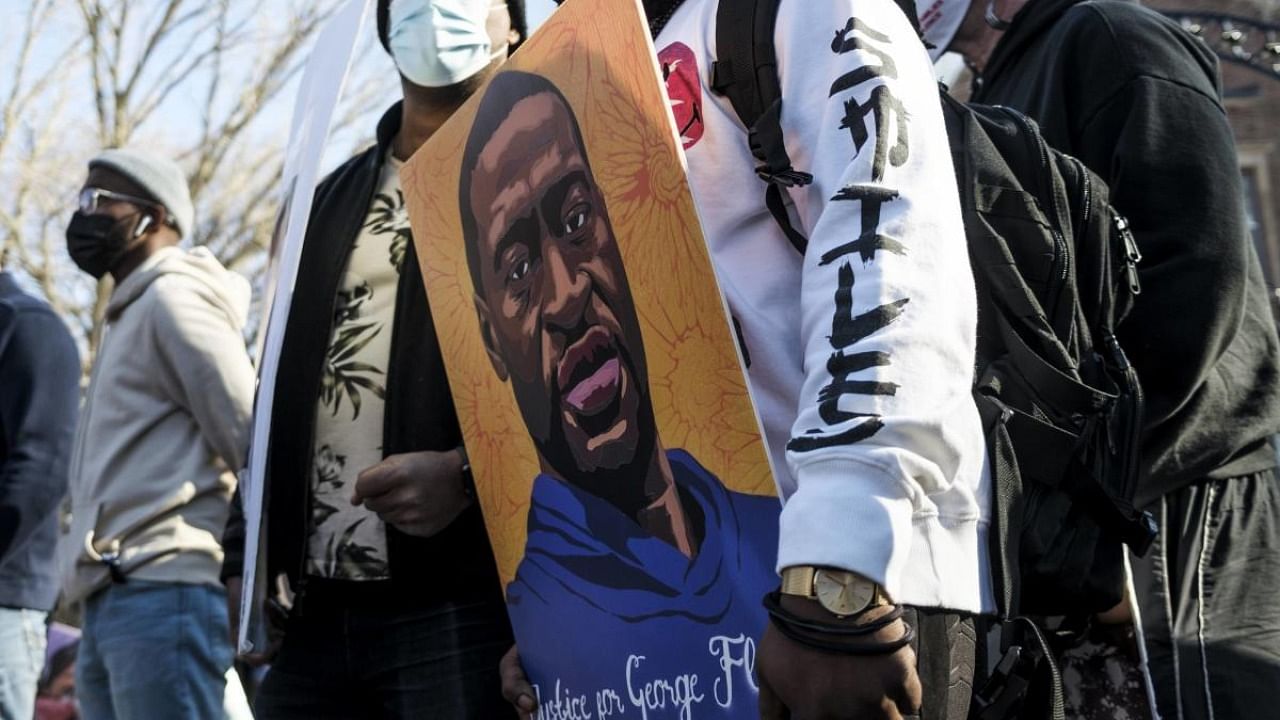  A man holds a portrait of George Floyd during a protest demonstration outside the Governors Mansion on March 6, 2021 in St. Paul, Minnesota. Credit: AFP.