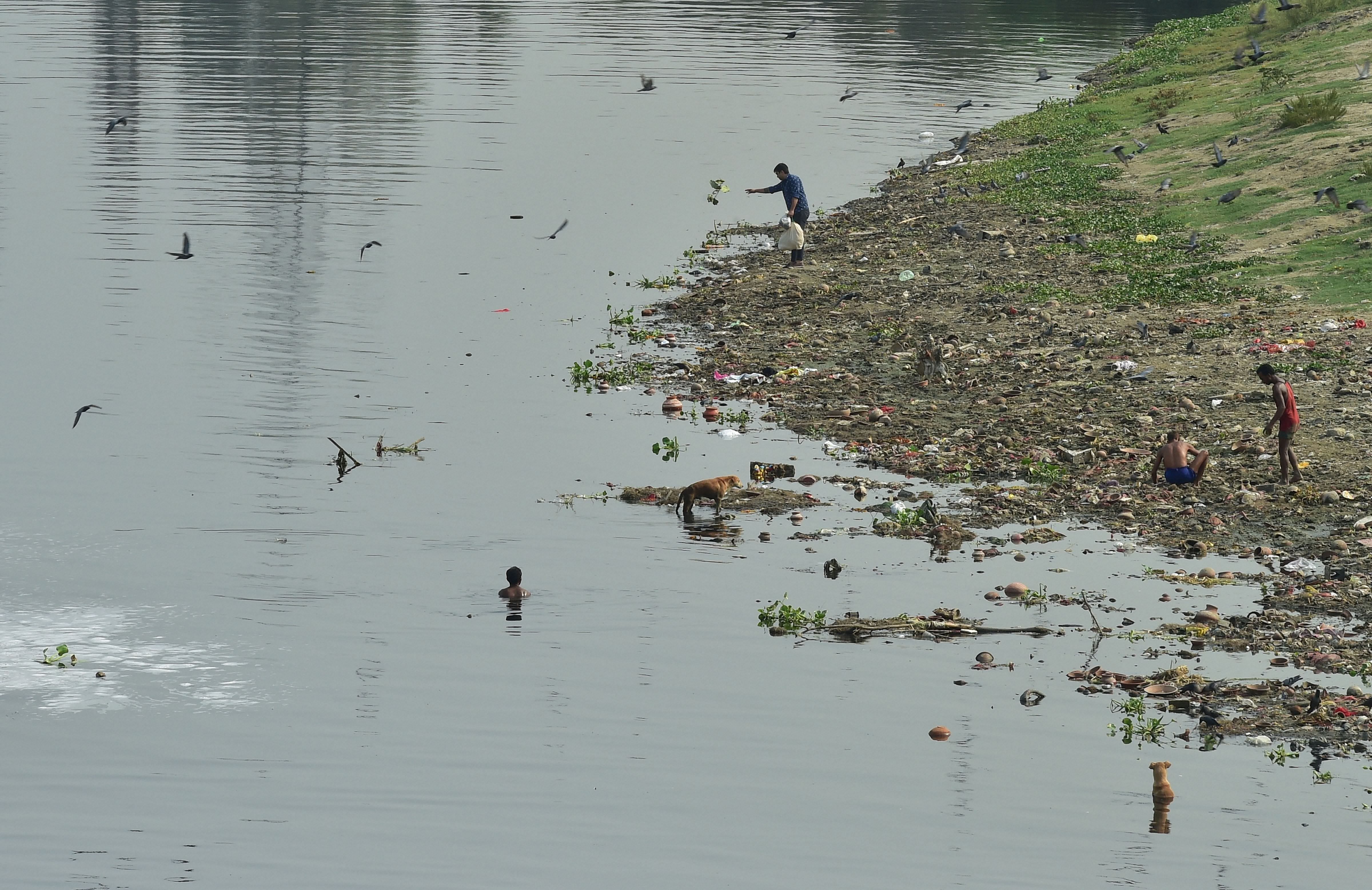 A man throws plastic bag as waste pickers search for valuables in the polluted waters of River Yamuna,in New Delhi, Wednesday, June 5, 2019. World Environment Day is celebrated each year on June 5 and the theme for this year is 'Air pollution'. Representative image/Credit: PTI File Photo