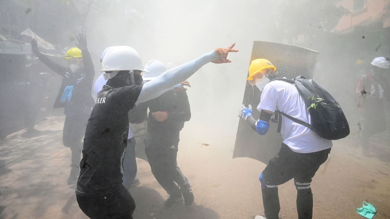 Protesters react after tear gas is fired by police during a demonstration against the military coup. Credit: AFP Photo