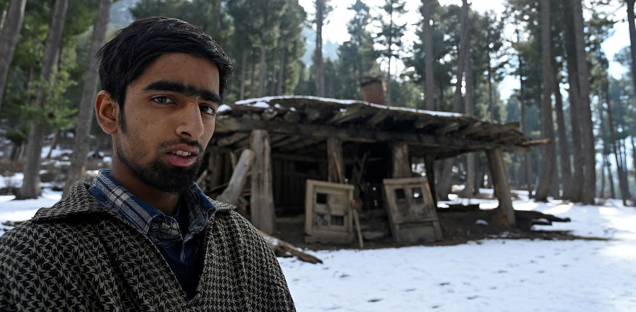 Bilal Ahmed Gorsi stands near his log house which was partially dismantled by forest officials as they claimed it was built illegally on encroached forest land at Lidroo village. Credit: AFP Photo