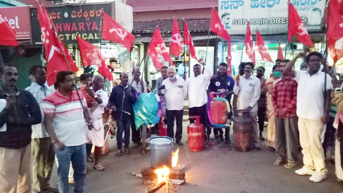 CPM leaders stage a protest in Nelyahudikeri by setting up a fireplace on the road and preparing coffee. Credit: DH Photo