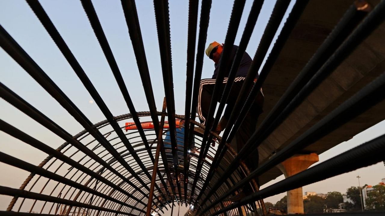 Workers labour on reinforcing steel at a flyover construction site in Patna, Bihar, India, on Thursday, Feb. 25, 2021. Credit: Bloomberg.