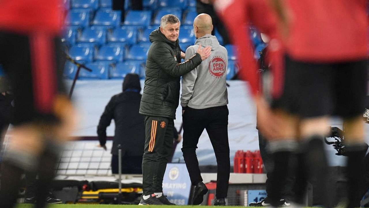 Manchester United's Norwegian manager Ole Gunnar Solskjaer (L) and Manchester City's Spanish manager Pep Guardiola (R) interact after the final whistle of the English Premier League football match between Manchester City and Manchester United at the Etihad Stadium in Manchester. Credit: AFP.
