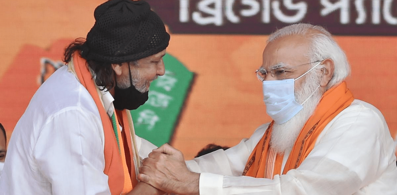 Prime Minister Narendra Modi exchanges greetings with Bollywood actor Mithun Chakraborty after he joined BJP during a public meeting ahead of West Bengal Assembly Polls, at Brigade Parade Ground in Kolkata. Credit: PTI photo.