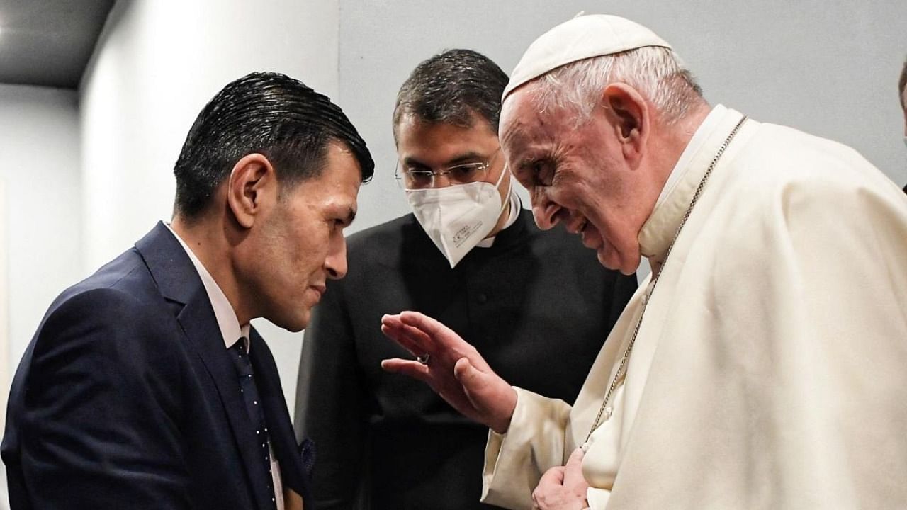 A handout picture released by the Vatican media office on March 7, 2021, shows Pope Francis talking to Abdullah Kurdi, father of Alan, the Syrian boy who made global headlines when his drowned body washed up on a beach in Turkey in 2015. Credit: AFP/Vatican Media/Handout.