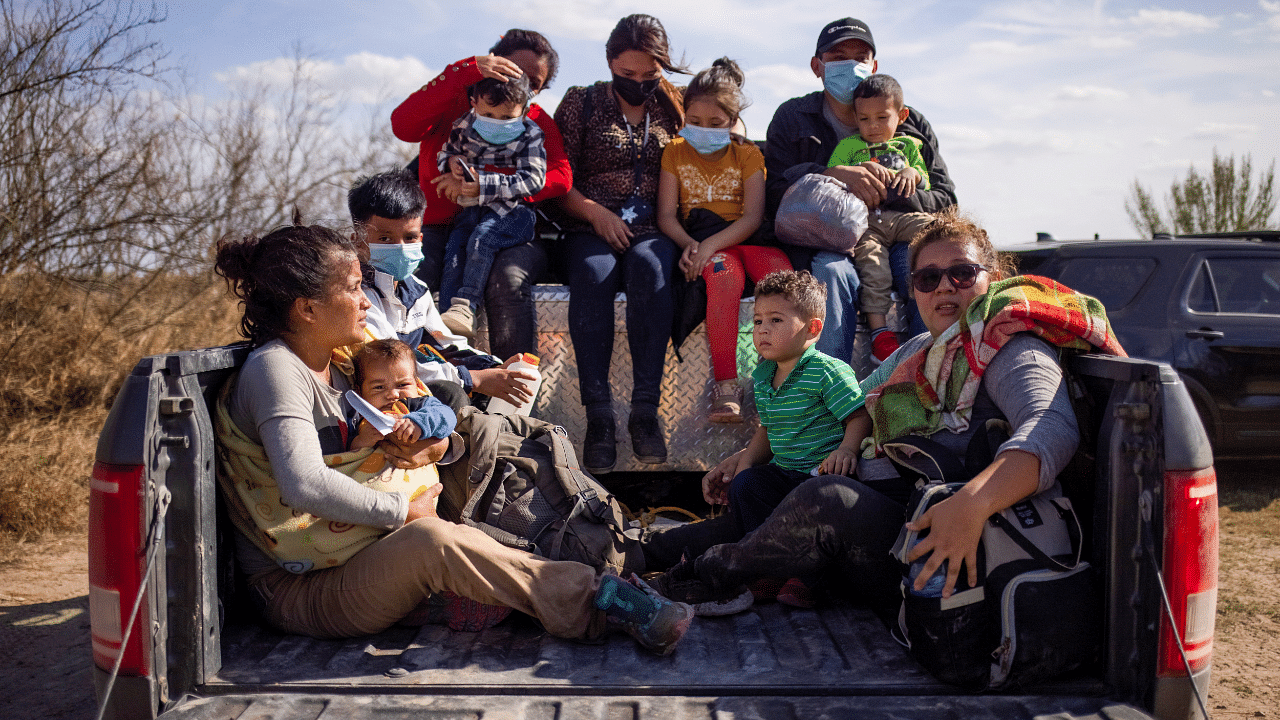 Migrant families sit in back of police truck for transport after crossing the Rio Grande River into the US from Mexico. Credit: Reuters Photo