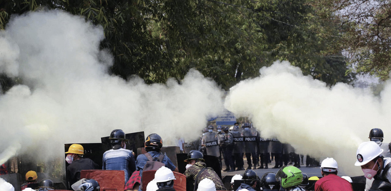 Anti-coup protesters discharge fire extinguishers to counter the impact of the tear gas fired by police during a demonstration in Myanmar. Credit: AP photo. 