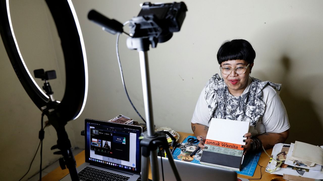 Ika Vantianti, an Indonesian artist, shows a handmade journal that reads on the cover 'for woman', as she mentors an online creative journaling workshop for women, which has been the part of an event to celebrate International Women's Day, in Jakarta, Indonesia, March 3, 2021. Credit: Reuters Photo