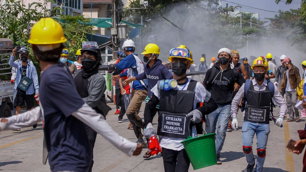 Anti-coup protesters retreat from the frontlines after discharging fire extinguishers towards a line of riot policemen in Yangon, Myanmar Wednesday, March 10, 2021. Credit: AP/PTI Photo