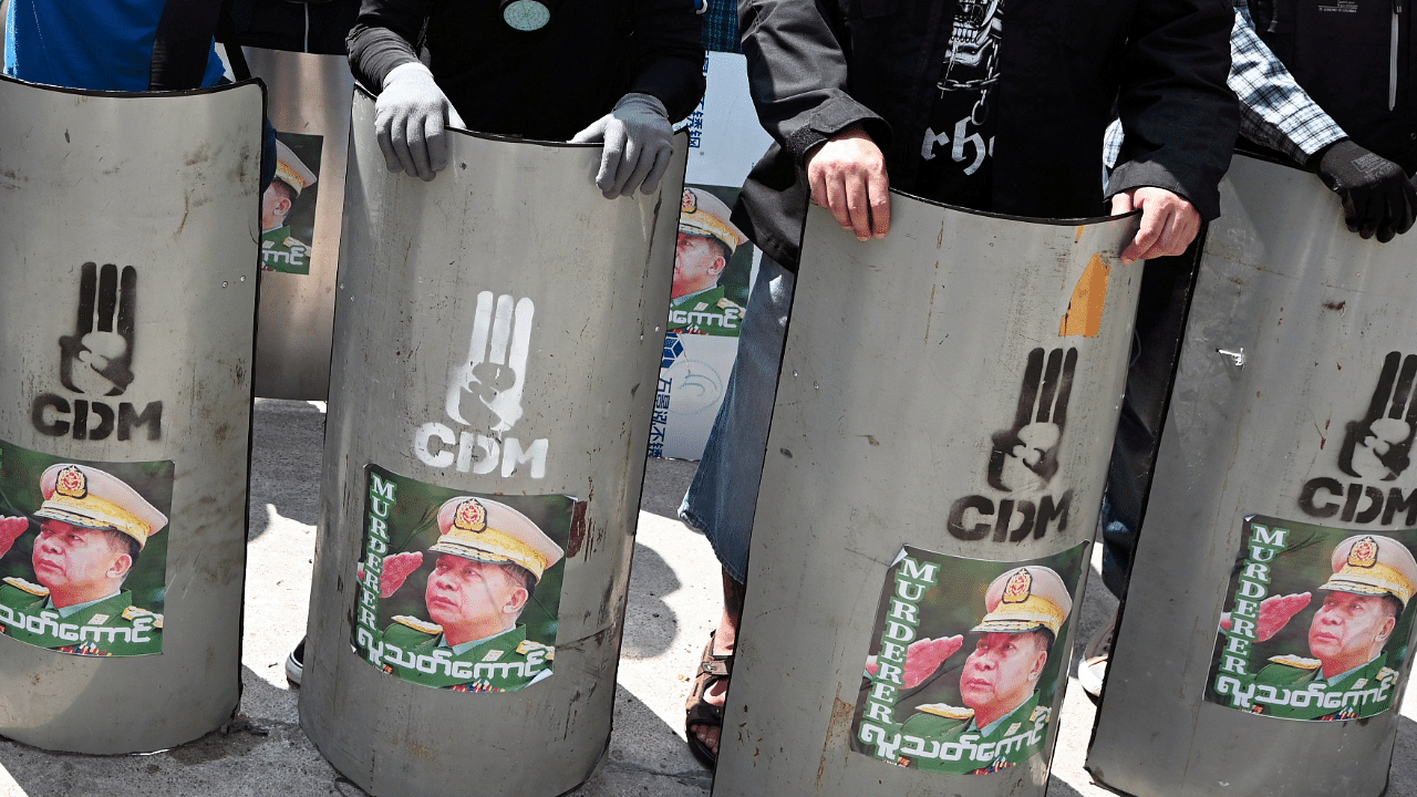 Demonstrators hold shields with attached pictures of Myanmar's military junta leader General Min Aung Hlaing. Credit: Reuters Photo