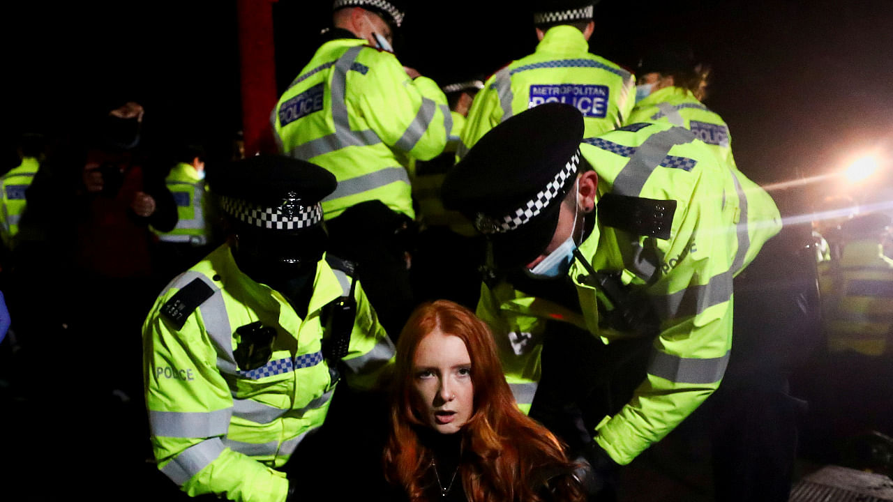 Police detain a woman as people gather at a memorial site in Clapham Common Bandstand. Credit: Reuters Photo