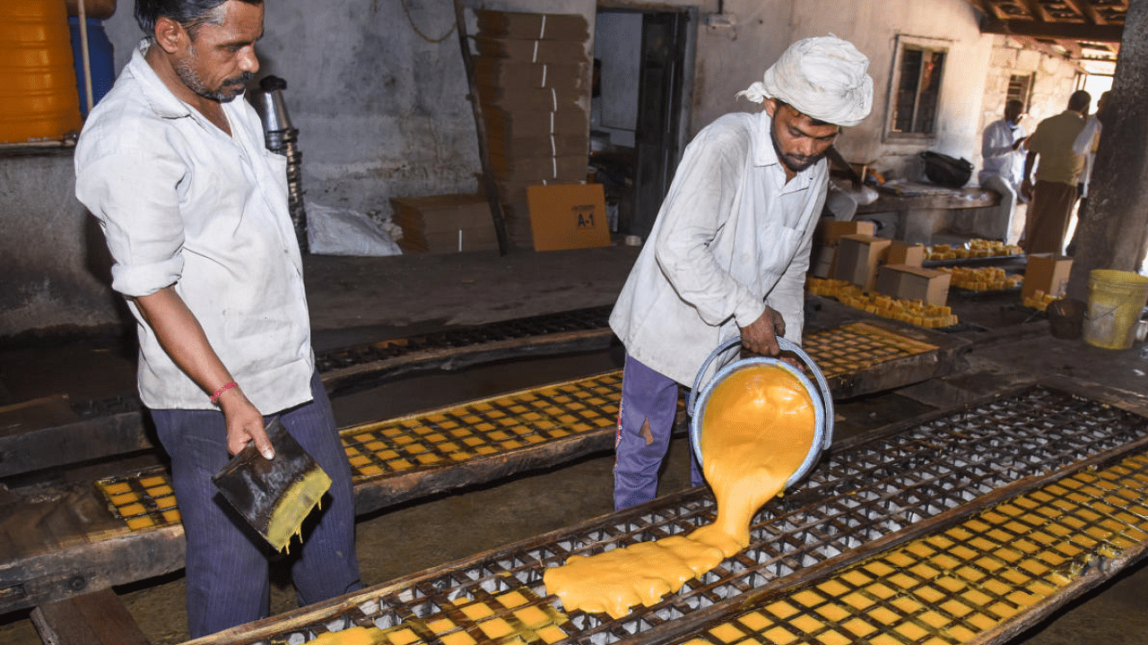 Liquid jaggery being poured into a square mould at a jaggery making unit in Mandya. Credit: DH Photo
