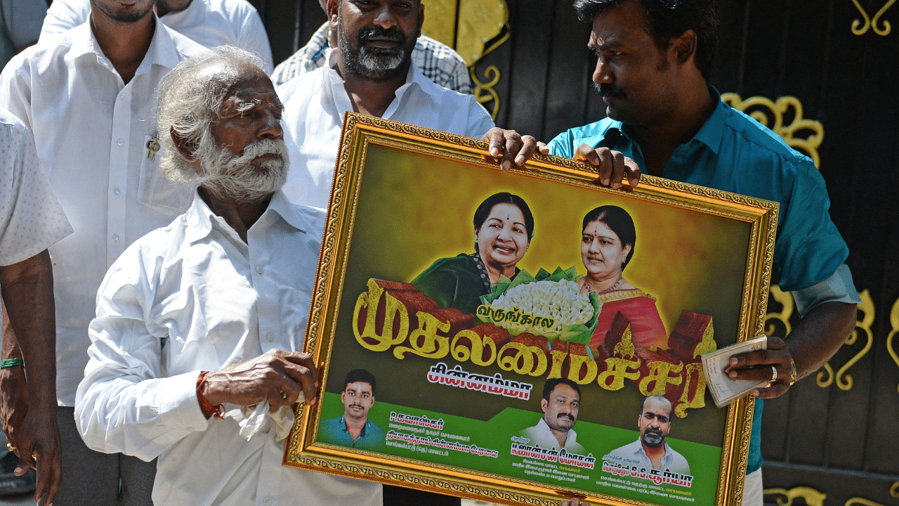 Supporters of the All India Anna Dravida Munnetra Kazhagam (AIADMK) leader V.K. Sasikala hold a picture of her and of late AIADMK leader J. Jayalalitha (L) during a protest in front of Sasikala's residence. Credit: AFP Photo