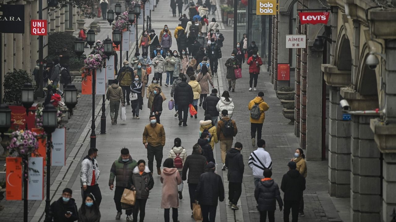 People walk along a pedestrian street in Wuhan, China's central Hubei province on January 23, 2021, one year after the city went into lockdown to curb the spread of the Covid-19 coronavirus. Credit: AFP File Photo