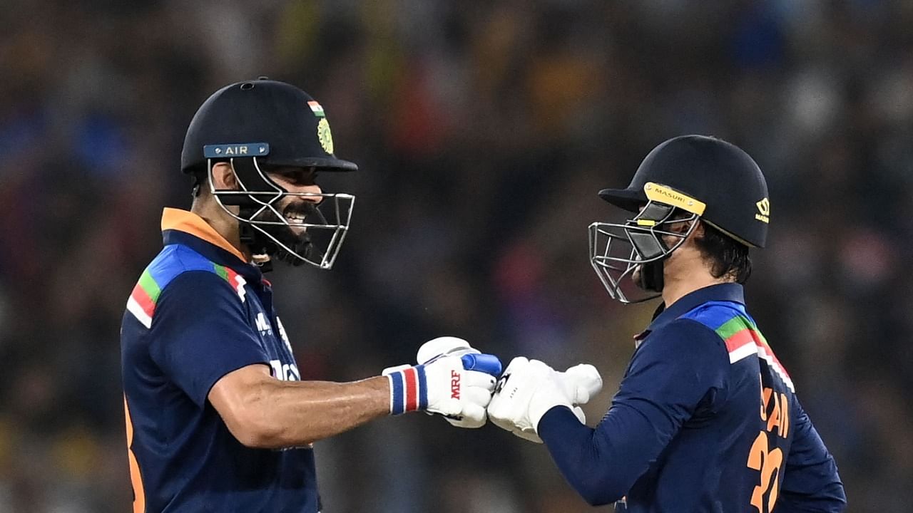 India's Ishan Kishan (R) is congratulated by captain Virat Kohli after he scored a half-century (50 runs) during the second Twenty20 international cricket match between India and England at the Narendra Modi Stadium in Motera on March 14, 2021. Credit: AFP Photo