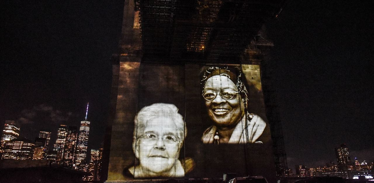  Images of New Yorkers lost to the Covid-19 pandemic projected on to the Brooklyn Bridge. Credit: AFP Photo