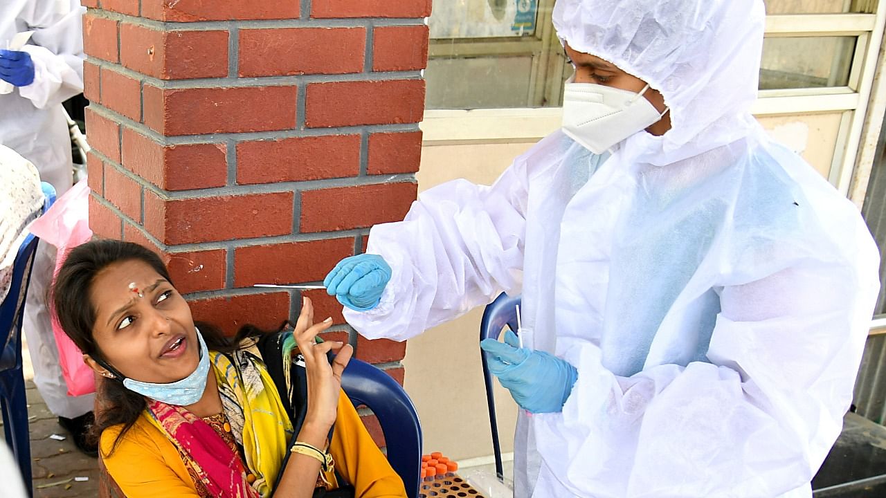 A woman hesitates to get tested for Covid-19 at the KSRTC Bus Stand in Majestic, Bengaluru. Credit: DH File Photo