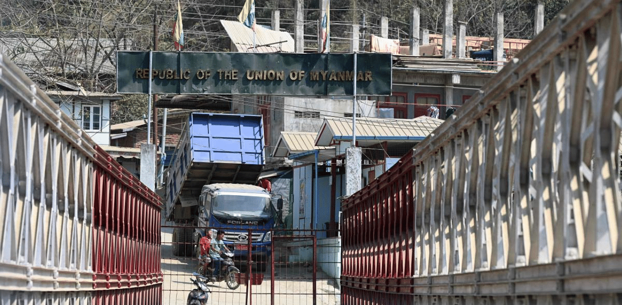 People ride a motorbike on the Myanmar's side near a bridge built over the Tiau river, a natural border between India and Myanmar at Zokhawthar in India's northeastern state of Mizoram. Credit: AFP Photo