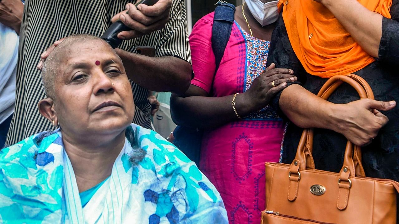 Kerala Mahila Congress Chief Lathika Subhash gets her head tonsured in front of the KPCC office, in protest against the denial of party ticket in the forthcoming assembly elections in Thiruvananthapuram. Credit: PTI Photo