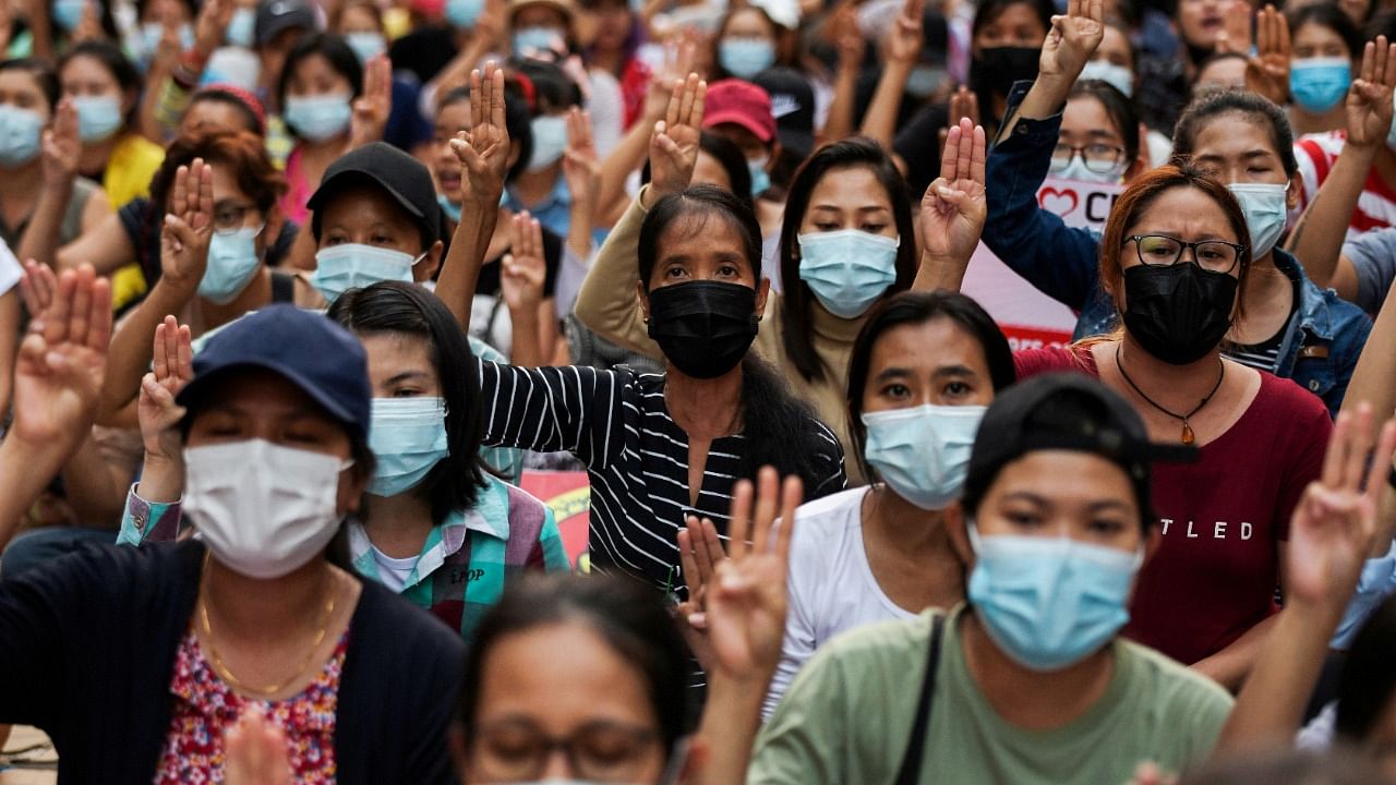 People flash a three-finger salute as they take part in an anti-coup night protest at Hledan junction in Yangon, Myanmar, March 14, 2021. Credit: Reuters Photo