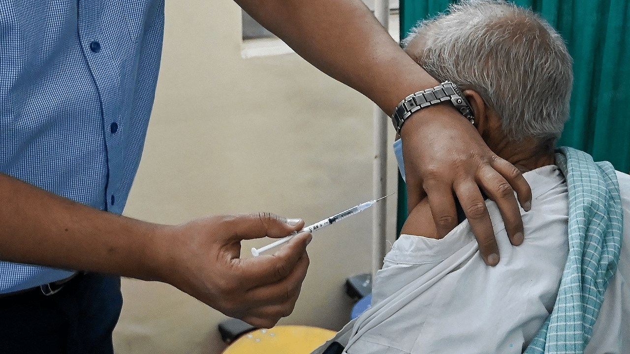 A medical worker inoculates an elderly man with a Covid-19 coronavirus vaccine at vaccination centre in New Delhi. Credit: AFP Photo