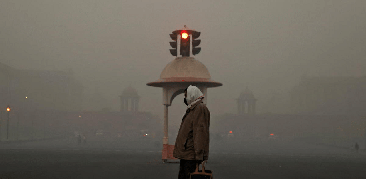 An office-goer walks past a traffic signal near various government ministries on a smoggy morning in New Delhi. Credit: Reuters Photo 