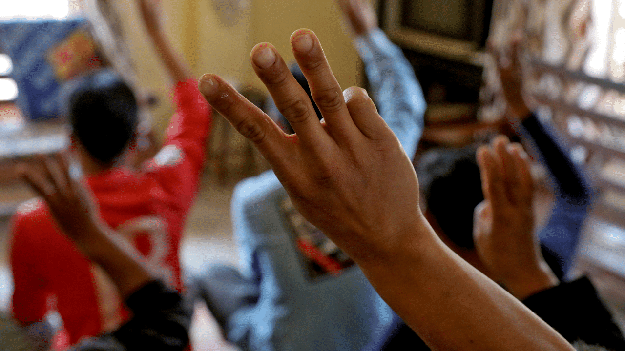 Myanmar nationals including those who said they are police and firemen and recently fled to India flash the three-finger salute at an undisclosed location in India's northeastern state of Mizoram. Credit: Reuters Photo