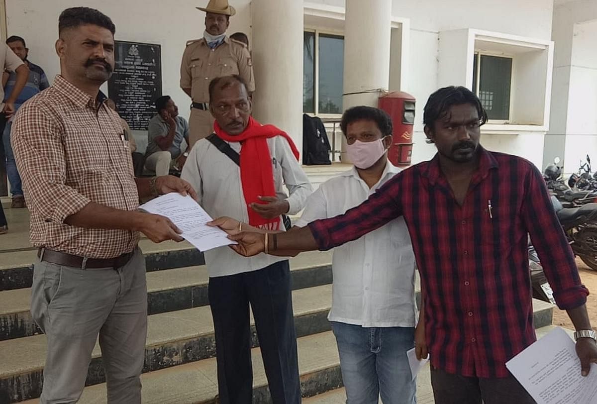 Demanding housing facilities for the tribal communities, members of SC/ST Hakkugala Horata Samithi submit a memorandum to Virajpet Tahsildar Yogananda. Credit: DH Photo