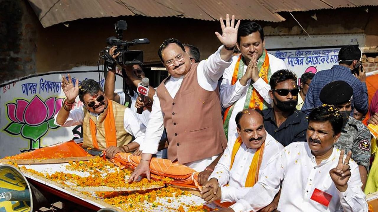 BJP National President JP Nadda waves at party supporters during an election campaign roadshow. Credit: PTI.