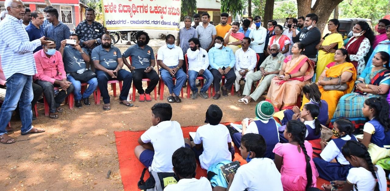 Members of Kiccha Sudeep Charitable Society (in grey t-shirts) interact with the students of Harijan Girl’s School in Hubballi on Wednesday. Credit: Dh Photo