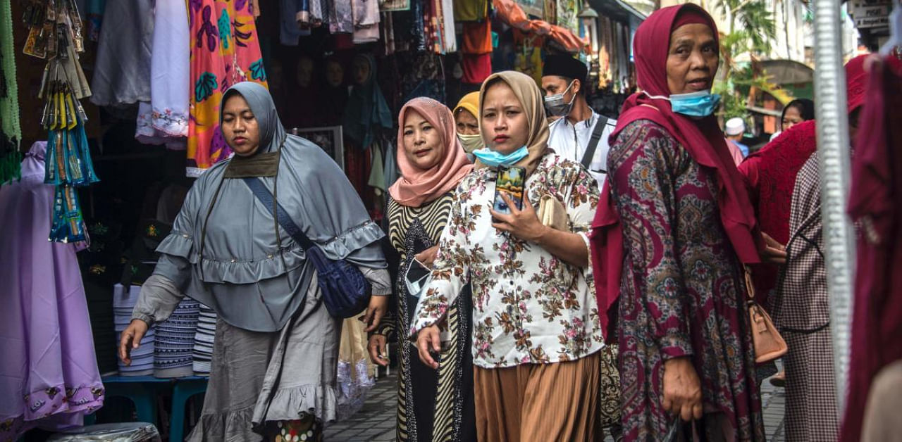  Women wearing hijabs shopping at a market in Surabaya. Credit: AFP photo. 