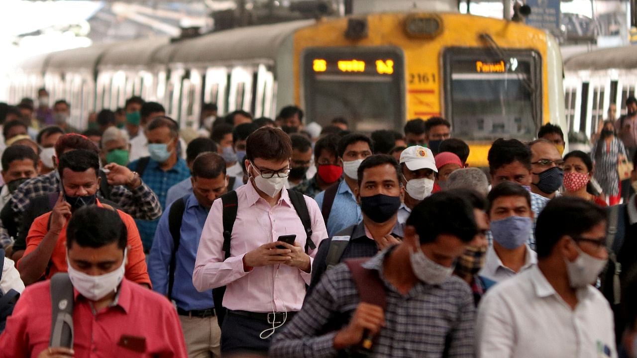 People wearing protective masks walk on a platform at the Chhatrapati Shivaji Terminus railway station, amidst the spread of the coronavirus, in Mumbai. Credit: Reuters File Photo