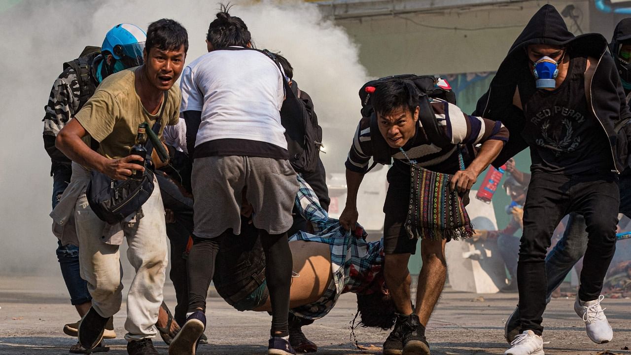 Protesters carry a wounded man shot with live rounds by security forces in Myanmar. Credit: AFP Photo
