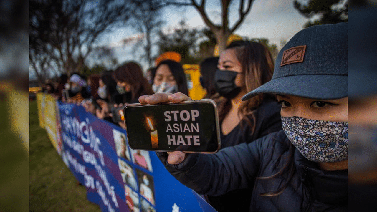 Julie Tran holds her phone during a candlelight vigil in Garden Grove, California, on March 17, 2021. Credit: AFP Photo
