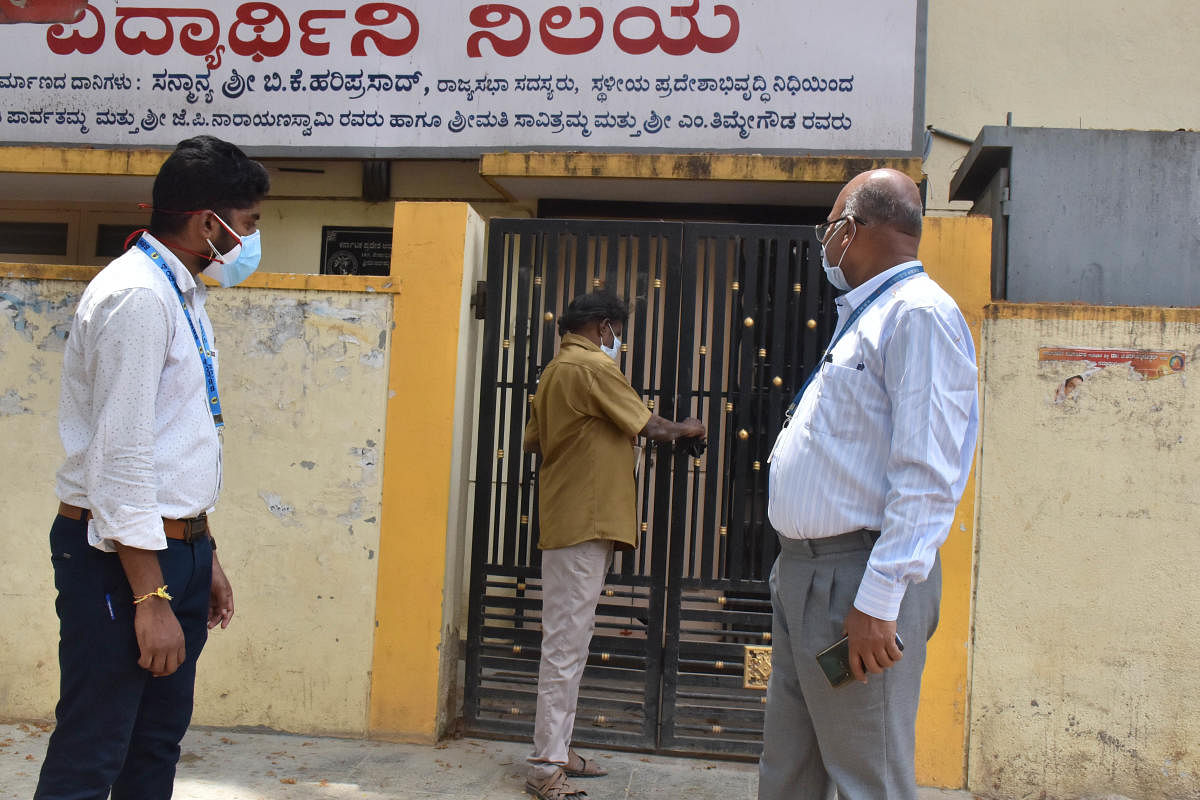 BBMP officials lock up a girls' hostel, in Bengaluru, where several Covid cases were reported on Thursday. DH PHOTO/JANARDHAN B K