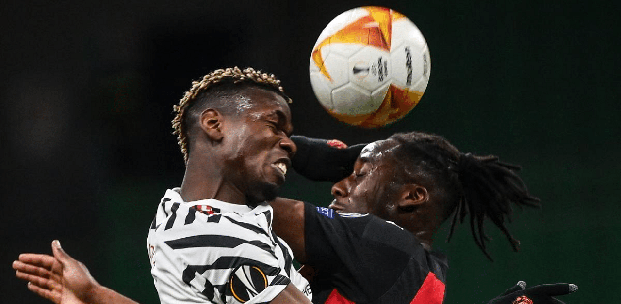 Manchester United's France's midfielder Paul Pogba (L) and AC Milan's French midfielder Souhaliho Meite go for a header. Credit: AFP photo. 