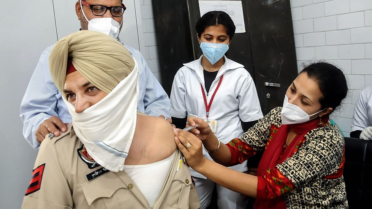 A medic administers a Covid-19 vaccine to a Punjab police officer, during a countrywide inoculation drive, in Patiala. Credit: PTI File Photo