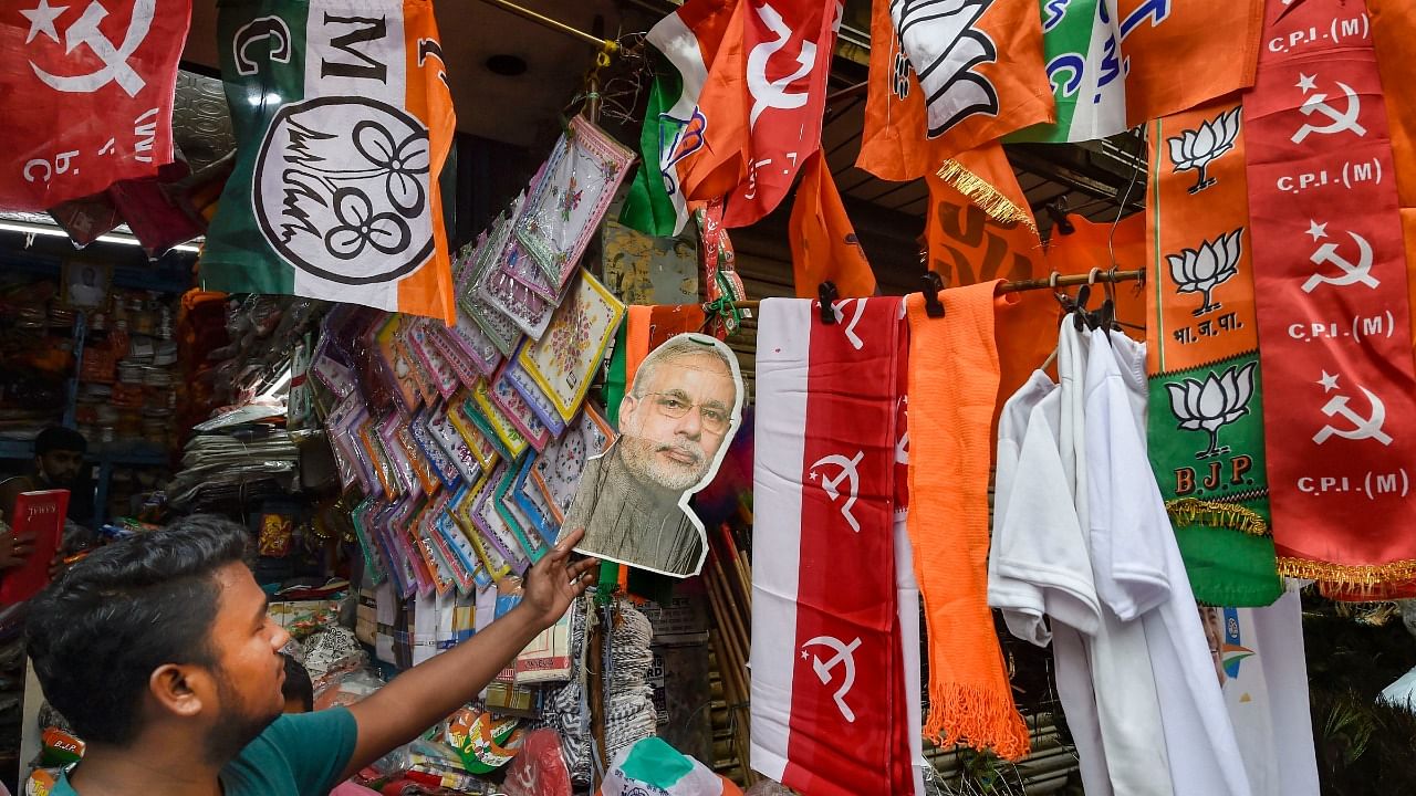 A shopkeeper sells political party symbols and flags at a shop, ahead of the State Assembly polls, in Kolkata, Thursday, March 18, 2021. Credit: PTI Photo