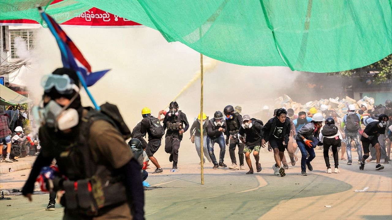 Protesters run during a crackdown on anti-coup protests at Hlaing Township in Yangon, Myanmar March 17, 2021. Credit: Reuters Photo