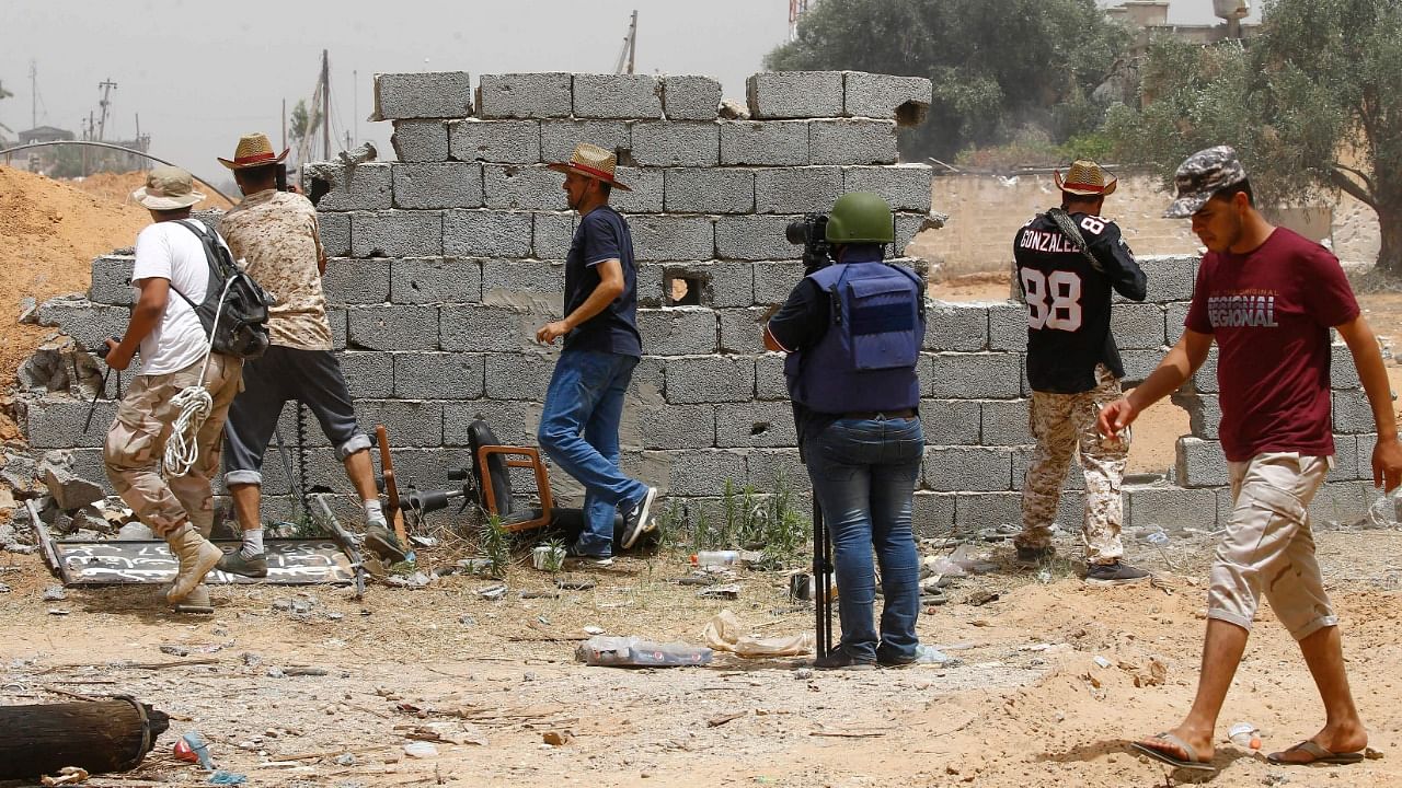 A file photo taken on June 13, 2019 shows a journalist covering the frontline during clashes between forces loyal to strongman Khalifa Haftar and fighters loyal to the Libyan internationally-recognised Government of National Accord (GNA), south of the Libyan capital Tripoli. Credit: AFP Photo