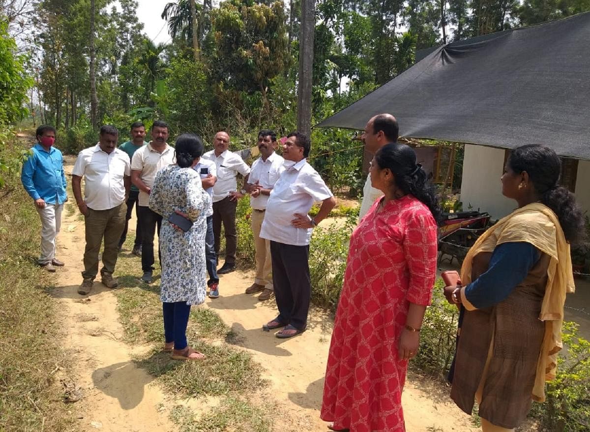 MLA K G Bopaiah inspects land for rehabilitation of people following cracks appearing on Ayyappa Betta and Nehru Nagara in Ambatti.
