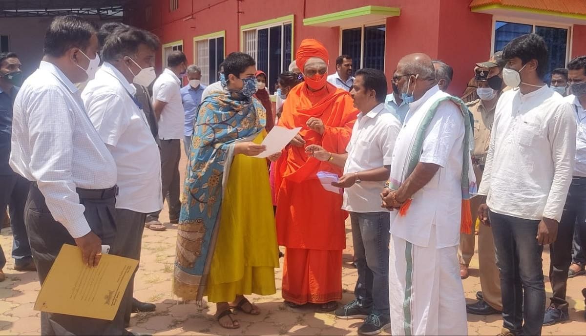 Kirikodli Mutt pontiff Sadashiva Swami holds a discussion with Deputy Commissioner Charulata Somal, on the dispute related to Rajara Gadduge, during a programme held at Kodlipet, near Shanivarasanthe.