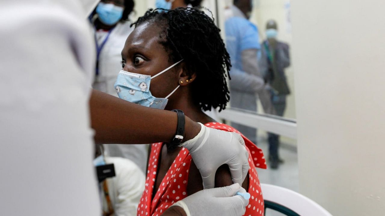 A woman reacts as she receives the AstraZeneca/Oxford vaccine under the COVAX scheme at the Kenyatta National Hospital in Nairobi. Credit: Reuters.