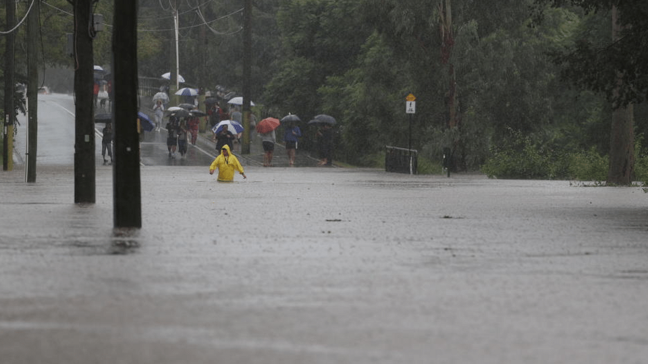 A person wades through floodwaters near the swollen Nepean River as the state of New South Wales experiences widespread flooding and severe weather, in Sydney, Australia, March 21, 2021. Credit: Reuters Photo